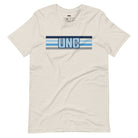 The letters "UNC" in bold blue over blue and white stripes for the University of North Carolina on a beige shirt.