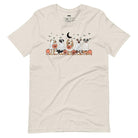 Beige t-shirt featuring a row of dogs dressed in ghost costumes with pumpkins, perfect for Halloween fun and dog lovers.