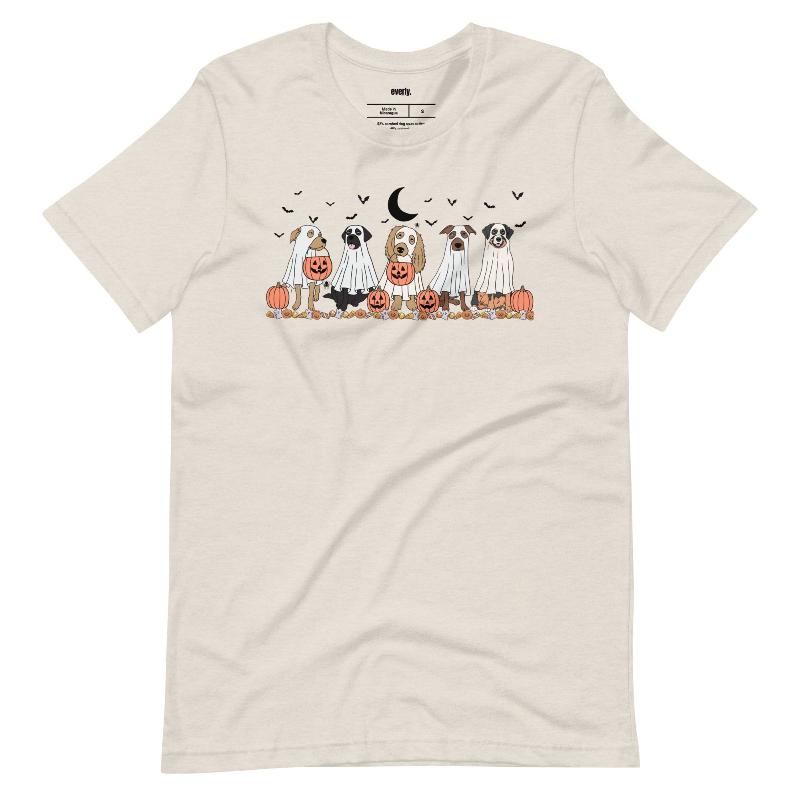 Beige t-shirt featuring a row of dogs dressed in ghost costumes with pumpkins, perfect for Halloween fun and dog lovers.