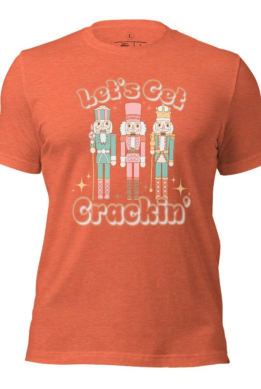 Get into the festive groove with our Christmas Nutcracker shirt that exclaims, "Let's Get Crackin'!" on a heather orange colored shirt. 