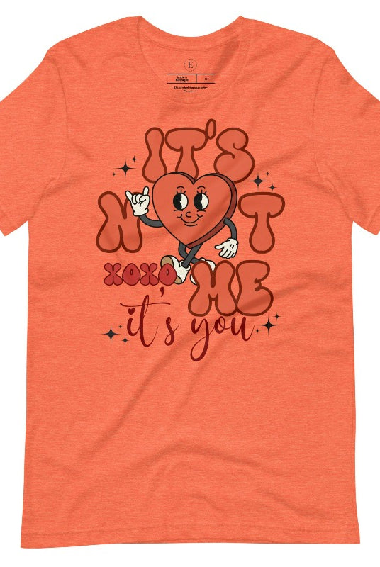 Celebrate Valentine's with our playful shirt! Featuring a bold heart and the message "It's not me, it's you," on a heather orange shirt. 