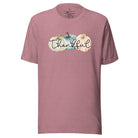 Express gratitude in style with our charming t-shirt. This design radiates autumn appreciation, featuring three pastel pumpkins and the word 'thankful' gracefully woven through the middle on a heather orchid colored shirt. 