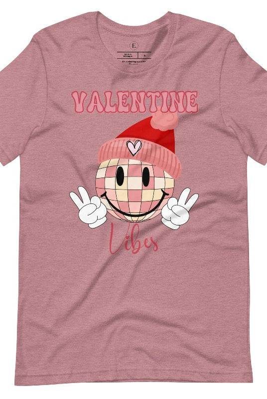 Get into the Valentine's Day spirit with our fun and funky shirt donning the words "Valentine Vibes" alongside a disco ball smiley face flashing peace fingers on a heather orchid coloed shirt. 