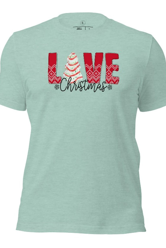 Spread love and joy this holiday season with our Christmas shirt featuring the classic Christmas tree cake, which is incorporated into the word "Love" on a heather prism dusty blue colored shirt.