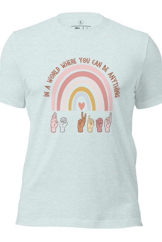 American sign language shirt with a rainbow and the phrase "In a world where you can be anything" and hands signing 'Be Kind' at the bottom on the rainbow on a heather prism ice blue colored shirt.