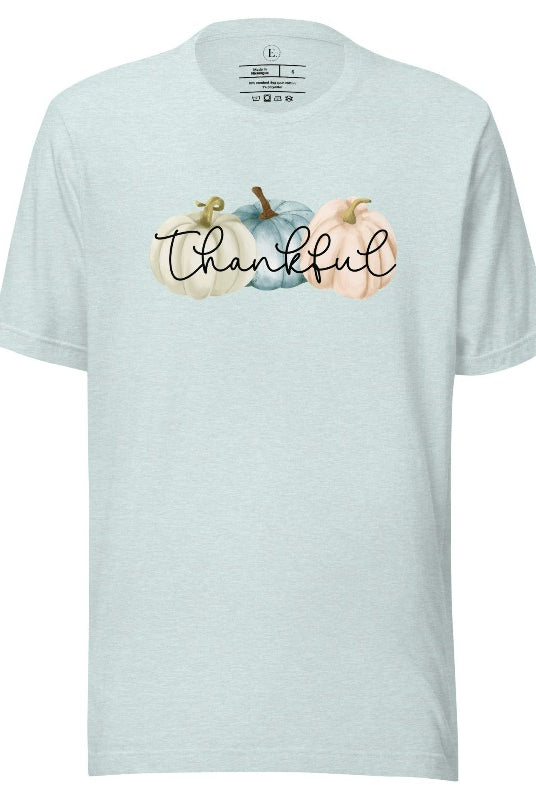 Express gratitude in style with our charming t-shirt. This design radiates autumn appreciation, featuring three pastel pumpkins and the word 'thankful' gracefully woven through the middle on a heather prism ice blue colored shirt. 