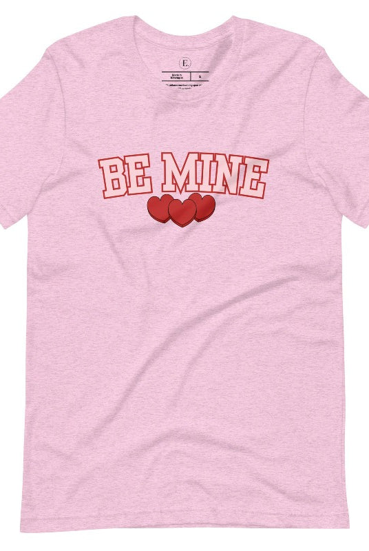 Elevate your Valentine's Day style with our "Be Mine" shirt! Featuring bold athletic lettering and three adorable hearts, on a heather prism lilac shirt. 