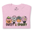 Pink t-shirt featuring a fun 'Sweet & Spooky' design with Halloween-themed ice cream cones, skulls, pumpkins, and spooky treats.