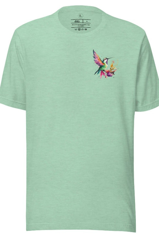 Elevate your style with our stunning t-shirt featuring a watercolor hummingbird delicately placed on the pocket on a heather prism mint shirt. 