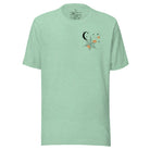 Embrace the enchanting night sky with our captivating t-shirt. Featuring a crescent moon, stars, and a spiderweb with three adorable spiders hanging down on the front pocket on a heather prism mint shirt. 