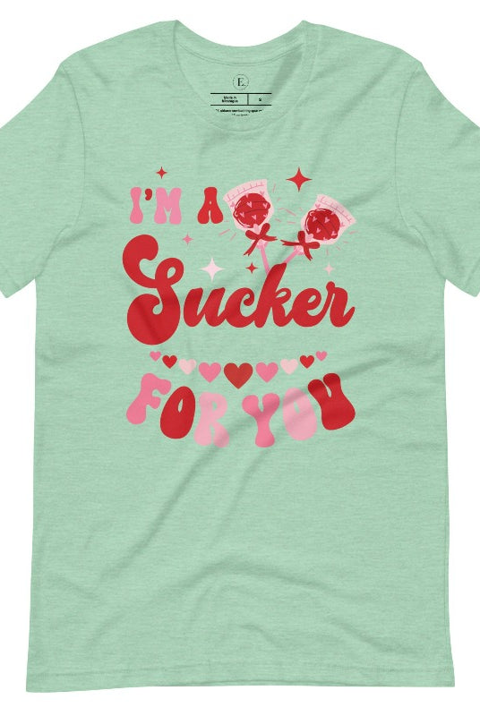 Indulge in the spirit of love with our Valentine's Day shirt! Adorned with charming Valentine lollipops and the playful saying, "I'm a sucker for you," on a heather prism mint shirt. 
