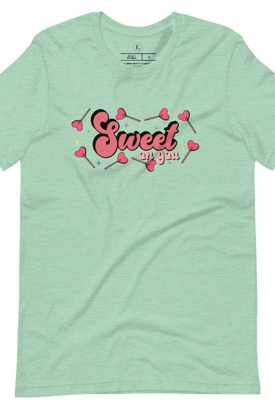Spread the love with our charming Valentine's Day shirt featuring the endearing phrase " Sweet on You" surrounded by heart lollipops on a heather prism mint shirt. 