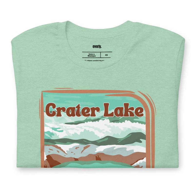 a colorful graphic of Crater Lake National Park, featuring mountains, water, and the text "Crater Lake National Park Oregon 1902 on a mint shirt. 