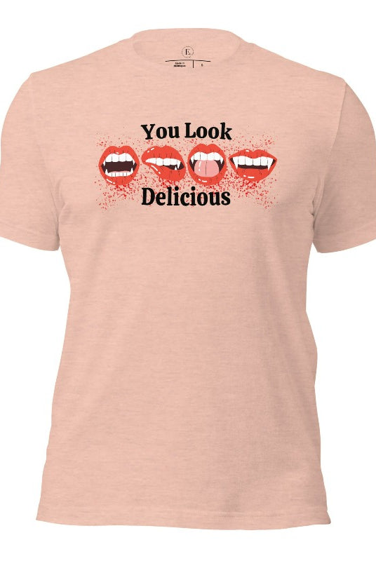 Indulge in wickedly delightful style with our vampire lips shirt. Featuring alluring lips dripping with Halloween allure, this shirt captivates with its seductive charm. The cheeky message, 'You Look Delicious,' on a heather prism peach shirt. 