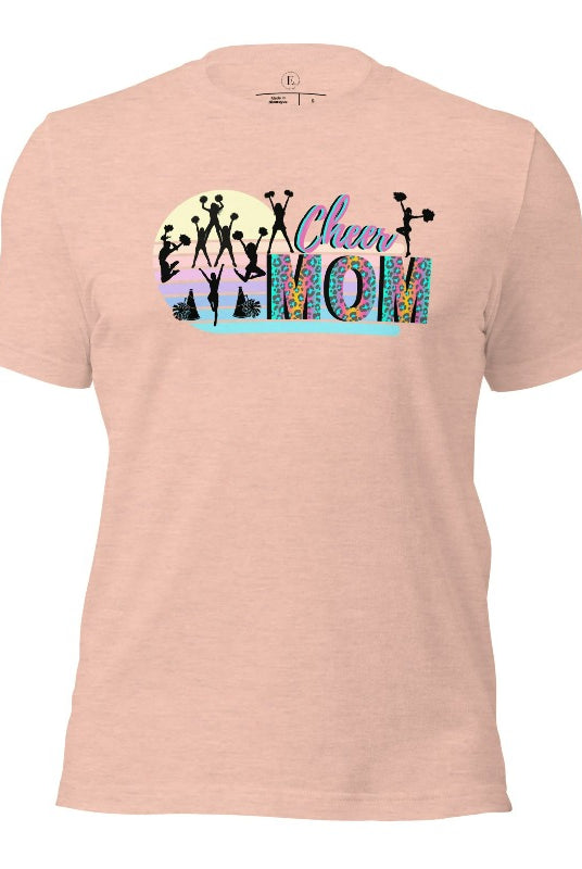 Get your cheer on with our stylish cheer mom shirt. Perfect for proud moms supporting their cheering stars. Made with love, this shirt combines comfort and fashion, letting you show off your team spirit. Join the cheer squad and cheer your heart out in style on a heather prism peach shirt. 