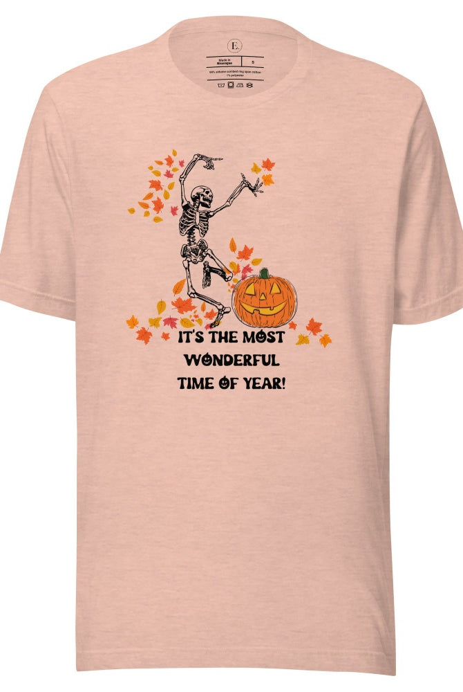 Dancing Skeleton in fall leaves with a jack-o-lantern with saying "It's the most wonderful time of year" on a heather prism peach colored shirt.