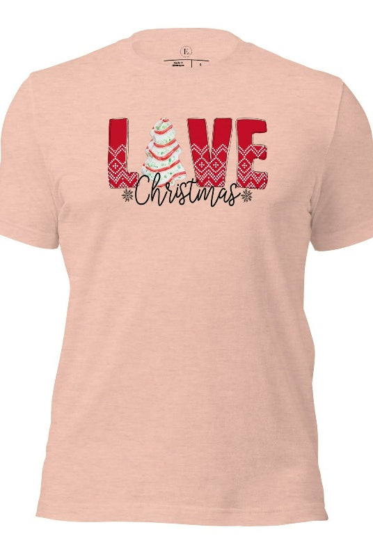 Spread love and joy this holiday season with our Christmas shirt featuring the classic Christmas tree cake, which is incorporated into the word "Love" on a heather prism peach colored shirt.