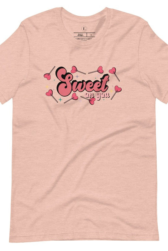 Spread the love with our charming Valentine's Day shirt featuring the endearing phrase " Sweet on You" surrounded by heart lollipops on a heather prism peach shirt. 