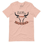 Unleash your cowboy spirit with our country western t-shirt boasting the statement "Not my First Rodeo" alongside bold bull horns and a lasso design on a heather prism peach shirt. 