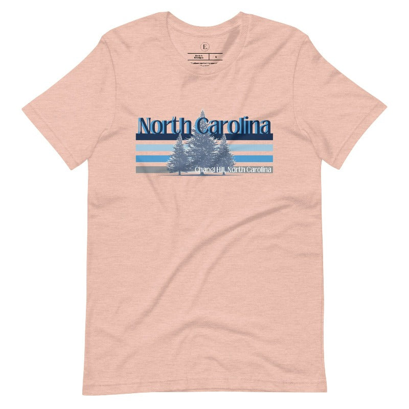 Show your school pride with this iconic North Carolina wordmark t-shirt. Made from premium materials, it features a North Carolina tree line in a the cool Carolina blue colors, representing a tradition of excellence for the nature that North Carolina offers on a heather prism peach shirt. 