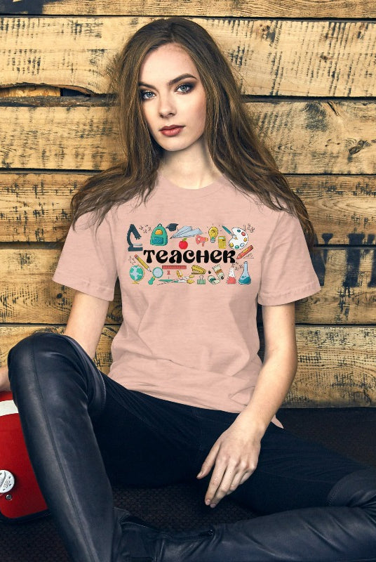 Teacher-themed graphic tee featuring the word 'Teacher' surrounded by all things related to teaching. Perfect for teacher shirts and teacher gifts. Peach graphic tees. 