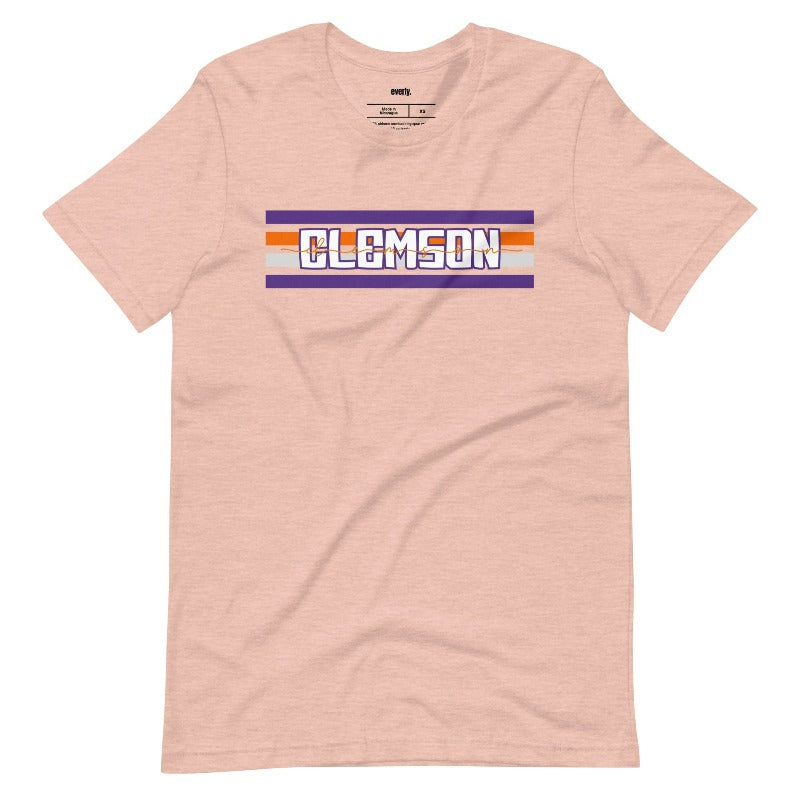 Bella + Canvas 3001 unisex shirt with Clemson University stripe design in purple, orange, and white, with "Clemson" written in bold letters on a heather prism peach graphic tee.