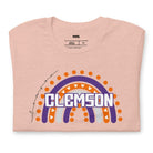 Bella + Canvas 3001 unisex shirt featuring a colorful rainbow design with the word "Clemson" in the center, representing Clemson University on a peach graphic tee.