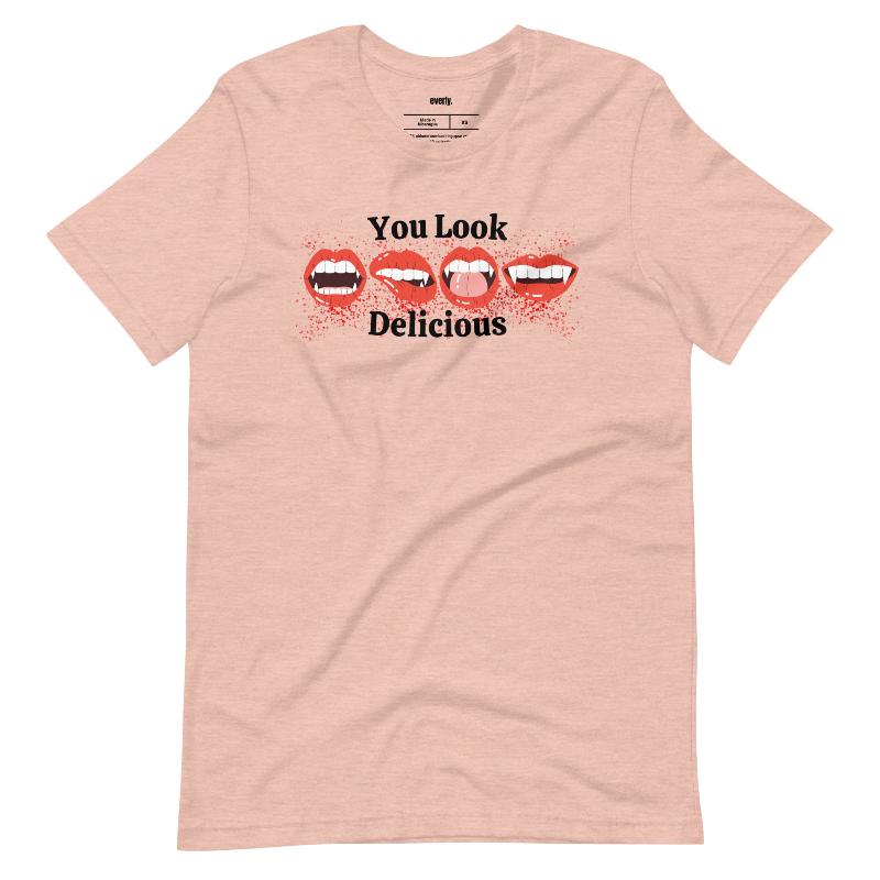 Peach t-shirt featuring a graphic of fanged red lips with the playful phrase "You Look Delicious" splattered in red, perfect for Halloween.