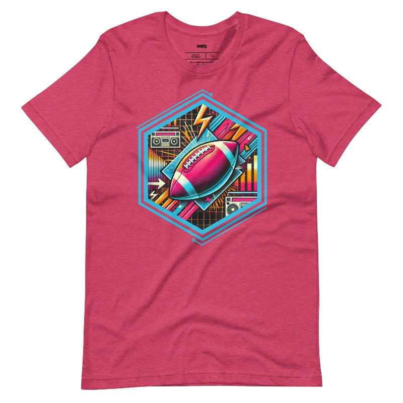 a vibrant neon design of a football with retro elements like boomboxes and geometric patterns, set in a hexagonal frame on a raspberry pink shirt.