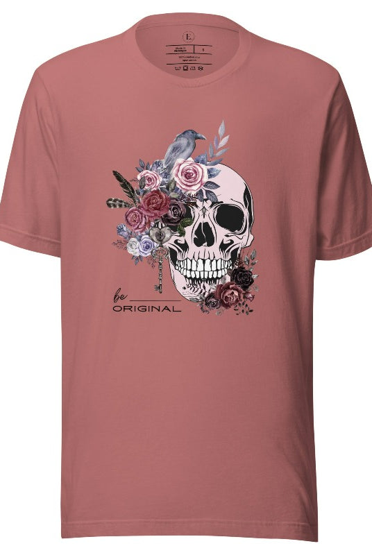 Looking for a unique Halloween shirt? Look no further! Our hauntingly beautiful shirt features a floral skull, raven, and the empowering slogan 'Be Original'. Stand out from the crowd with this unforgettable statement piece on a mauve shirt. 
