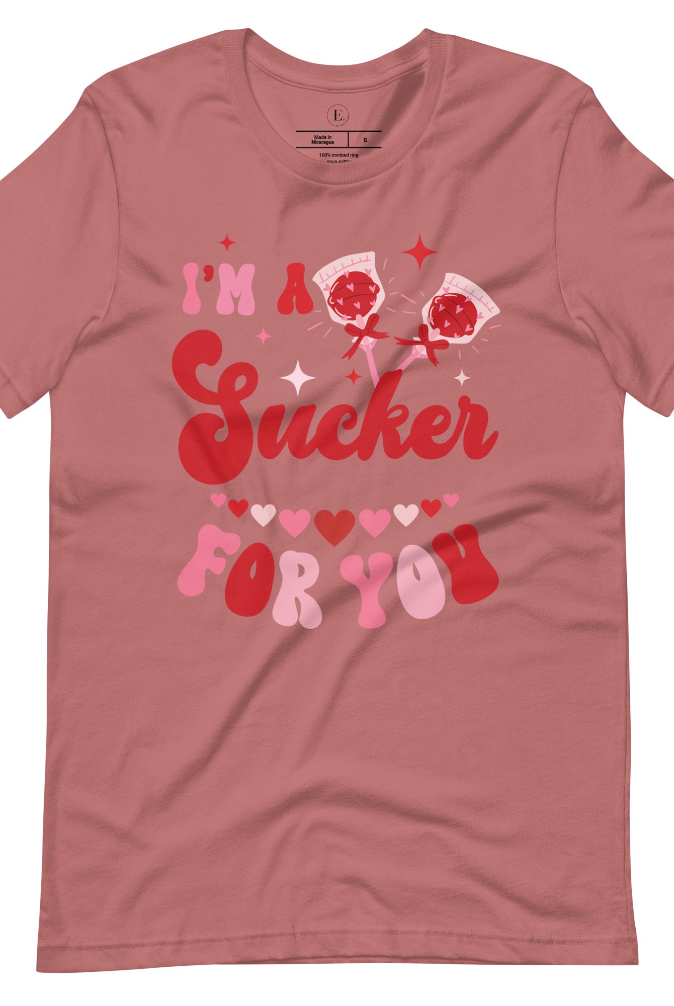 Indulge in the spirit of love with our Valentine's Day shirt! Adorned with charming Valentine lollipops and the playful saying, "I'm a sucker for you," on a mauve shirt. 