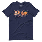  'Tis The Season' design with fall-themed graphics including a cupcake, maple leaf, football, and pumpkin, surrounded by falling leaves on a navy shirt. 