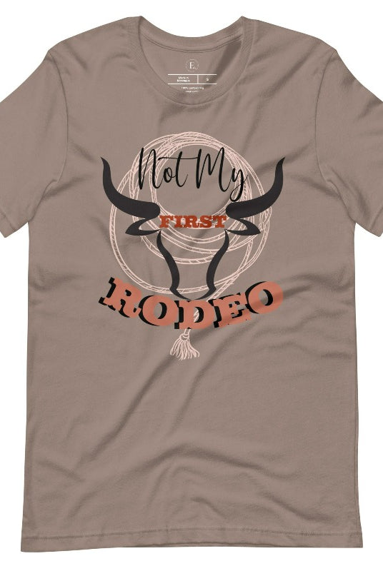 Unleash your cowboy spirit with our country western t-shirt boasting the statement "Not my First Rodeo" alongside bold bull horns and a lasso design on a pebble shirt. 