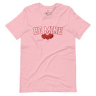 Elevate your Valentine's Day style with our "Be Mine" shirt! Featuring bold athletic lettering and three adorable hearts, on a pink shirt. 