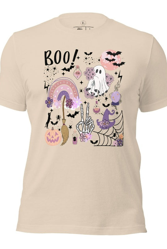 Experience the essence of Halloween with our bewitching shirt. Immerse yourself in a tapestry of Halloween symbols, from pumpkins to bats and witches, and all centered around the timeless exclamation, 'Boo!' This captivating design embodies the spirit of the season, on a soft cream colored shirt. 