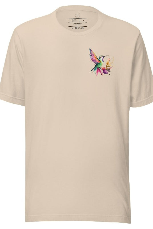 Elevate your style with our stunning t-shirt featuring a watercolor hummingbird delicately placed on the pocket on a soft cream shirt. 