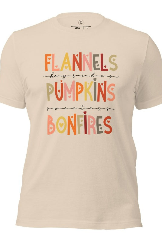 Embrace the cozy spirit of fall with our Flannel, Hayrides, Pumpkins, Sweaters, Bonfires shirt. Featuring the iconic fall elements, this shirt celebrates the season of warmth and comfort on a soft cream shirt. 