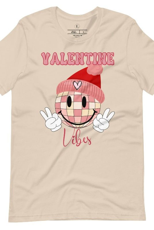 Get into the Valentine's Day spirit with our fun and funky shirt donning the words "Valentine Vibes" alongside a disco ball smiley face flashing peace fingers on a soft cream shirt. 