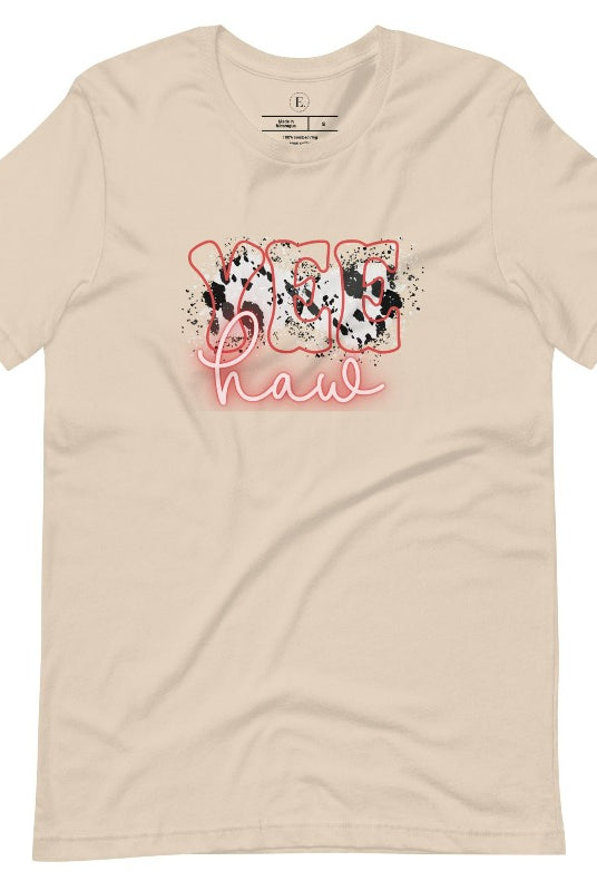 Saddle up in style with our country western shirt featuring the spirited exclamation "Yeehaw" set against a sleek cowhide print background, accented with neon pink lettering on a soft cream colored shirt. 
