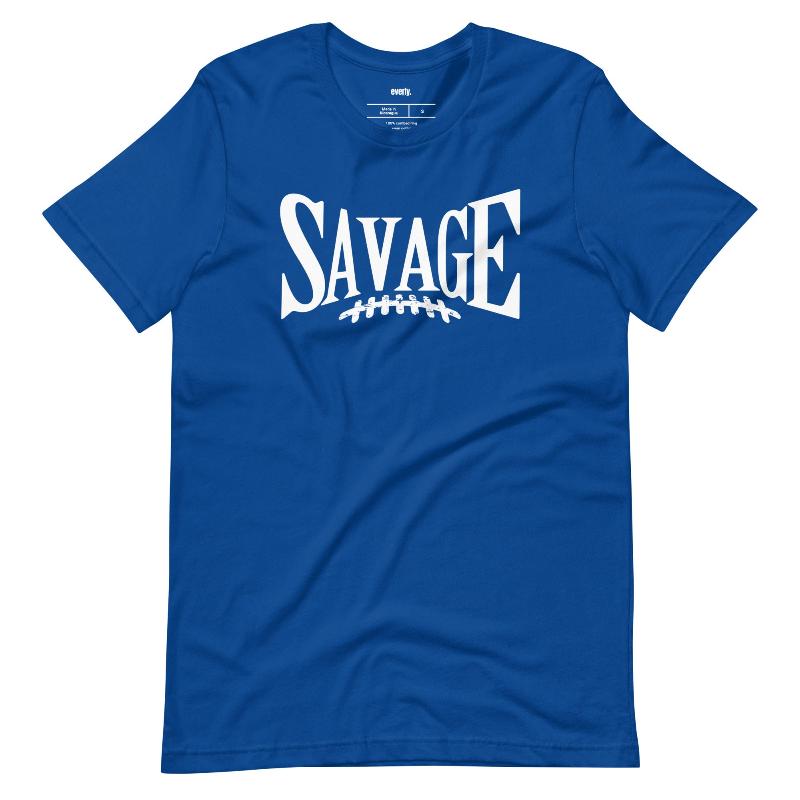 "Savage" in large, bold white letters with a football graphic underneath. The shirt is from Bella + Canvas and is made of 100% combed and ring-spun cotton on a blue shirt