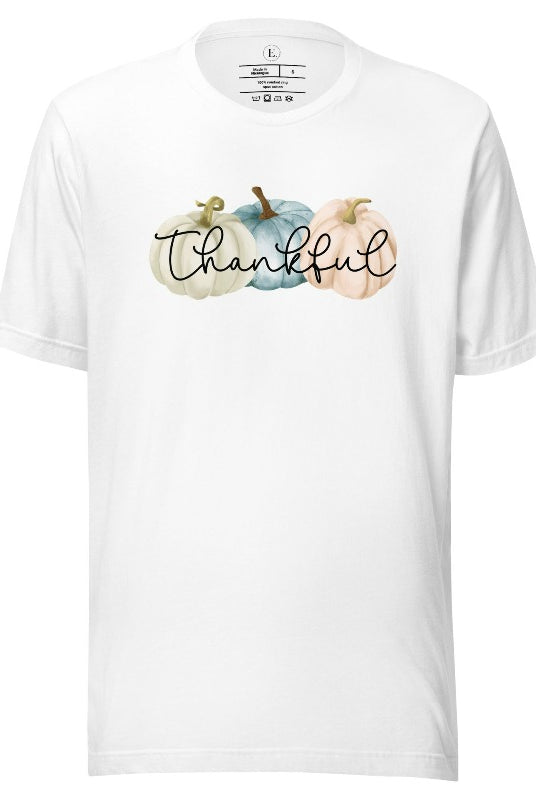 Express gratitude in style with our charming t-shirt. This design radiates autumn appreciation, featuring three pastel pumpkins and the word 'thankful' gracefully woven through the middle on a white shirt. 