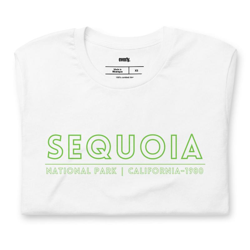 a colorful, detailed graphic of Sequoia National Park with the park's name and established year on the back, and a simplified text logo on the front on a white shirt.