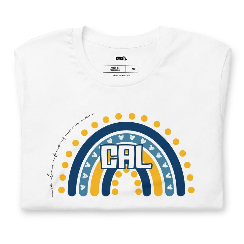 Bella + Canvas 3001 unisex t-shirt featuring a playful blue and gold rainbow design with "CAL" in the center, surrounded by hearts and dots on a white graphic tee.