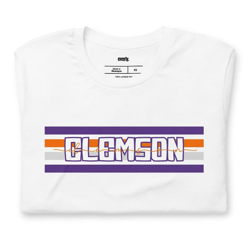 Bella + Canvas 3001 unisex shirt with Clemson University stripe design in purple, orange, and white, with "Clemson" written in bold letters on a white graphic tee.