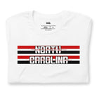 "North Carolina" in bold red and white text on a black and red striped background across the chest on a white shirt.