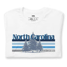 Serene Chapel Hill pine tree design with "North Carolina" and blue and white stripes on a white graphic tee.