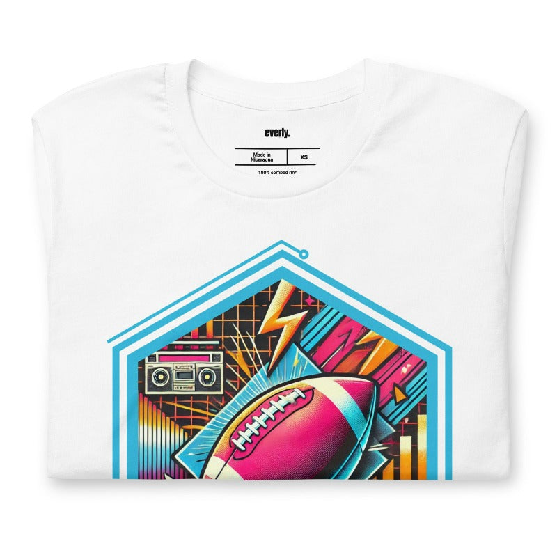 a vibrant neon design of a football with retro elements like boomboxes and geometric patterns, set in a hexagonal frame on a white shirt.