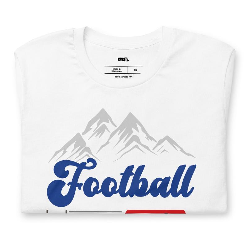 "Football," "The Perfect Sunday," and "Beer" in blue, red, and glittery blue lettering. The design includes a mountain backdrop and a goalpost, capturing the spirit of a perfect football Sunday on a white shirt.