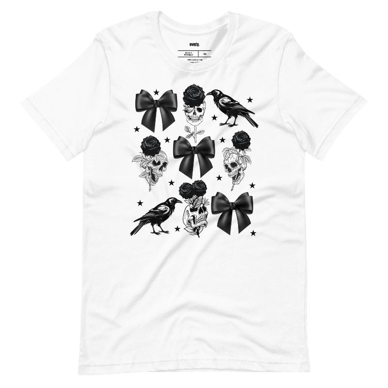 A white unisex t-shirt featuring a Halloween-themed design with black roses, skulls, ravens, bows, and stars. The design is printed in black and white, giving it a gothic and spooky vibe.