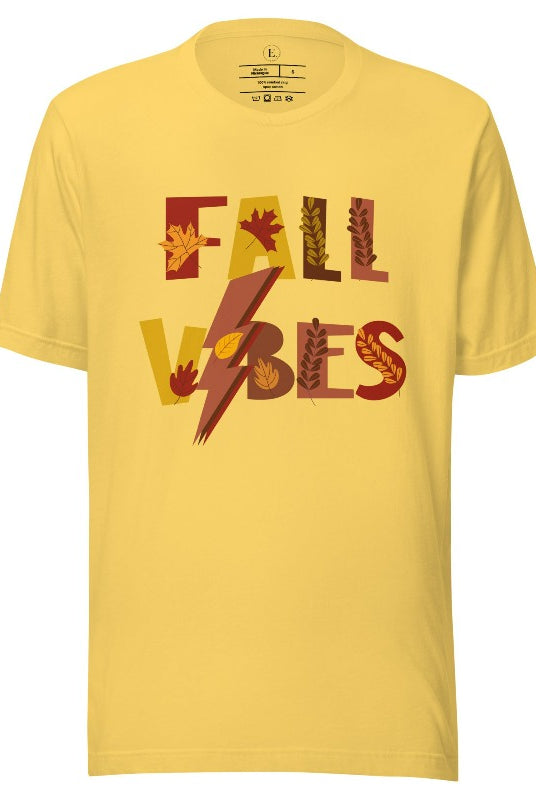 Get into the autumn spirit with our Fall Vibes shirt. Featuring the words 'Fall Vibes' with a creative twist- a lighting bolt replacing the 'I'- this shirt captures the energy of the season. Adorned with leaves, it adds a touch of nature's beauty on a yellow shirt. 